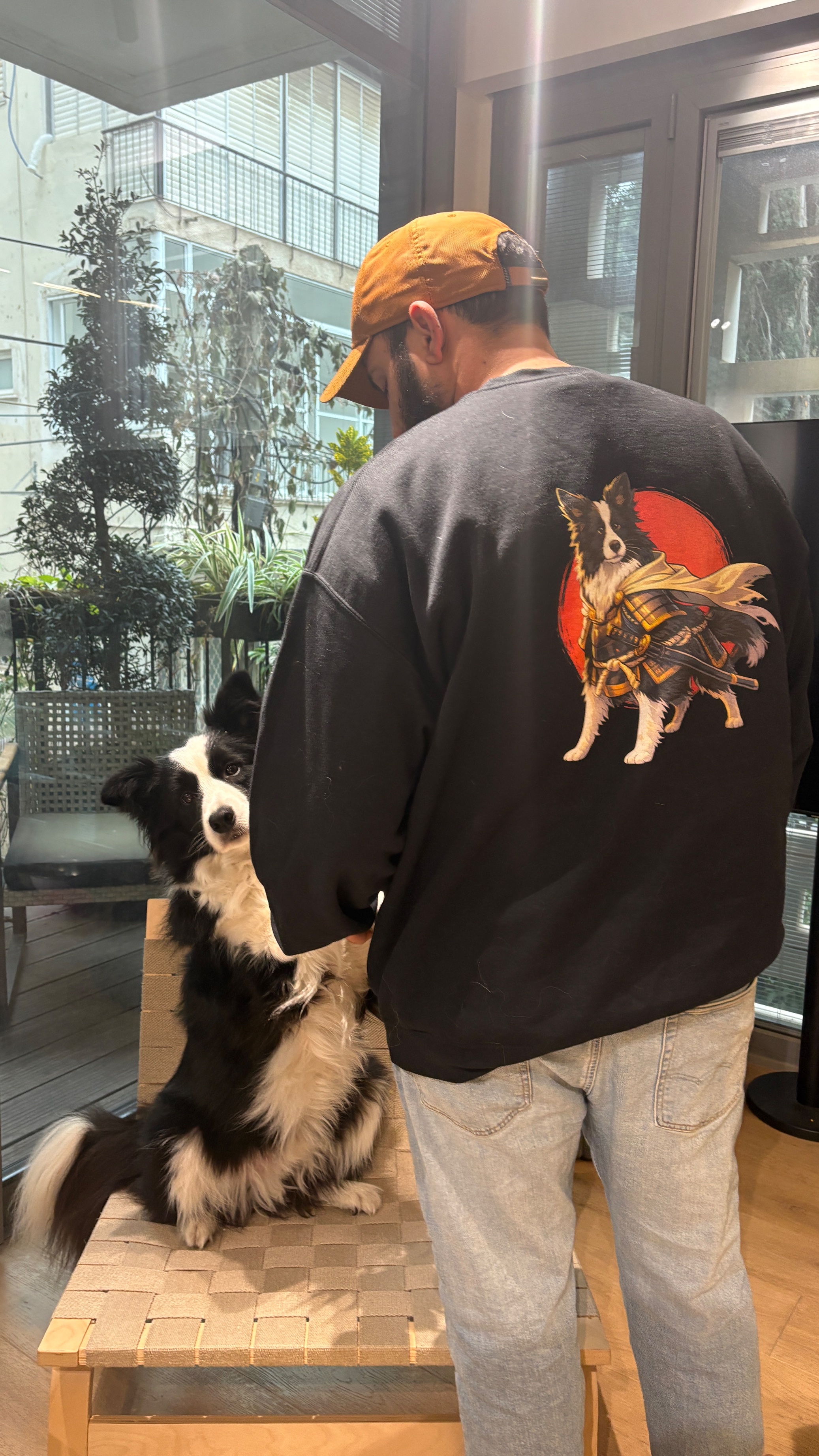 Hen wearing a samurai-Zuko crewneck sweatshirt while Zuko, the actual dog from the print, reaches up beside him